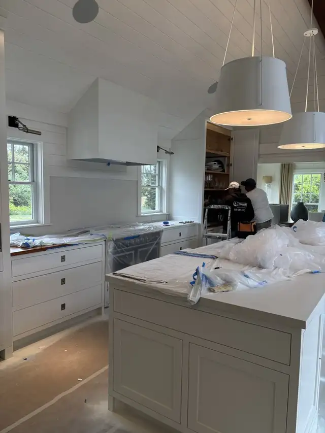 Hyannis Painting crew working in a kitchen with counters and floor protected